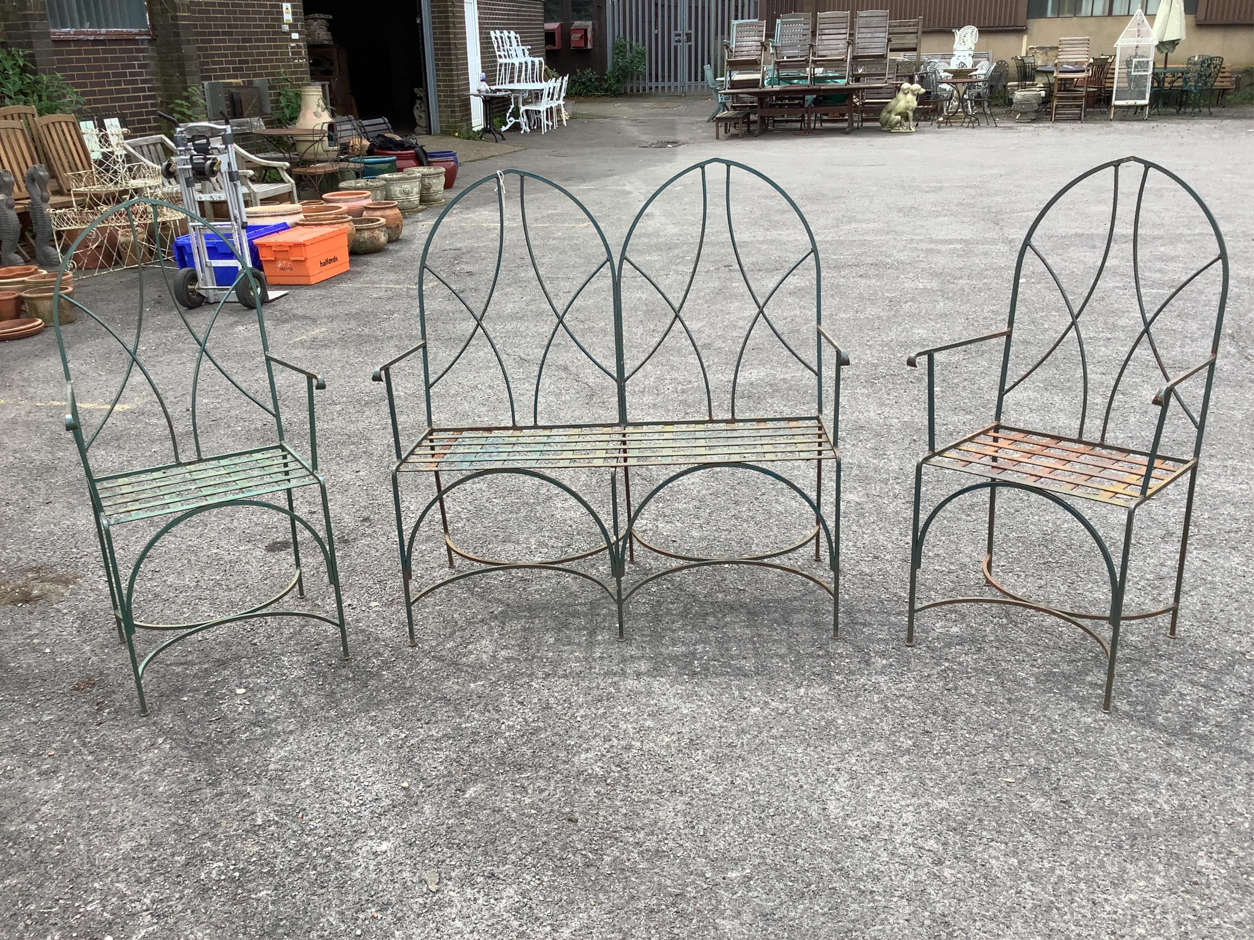 A painted wrought iron Gothic style three piece garden suite, bench width 109cm, depth 44cm, height 112cm